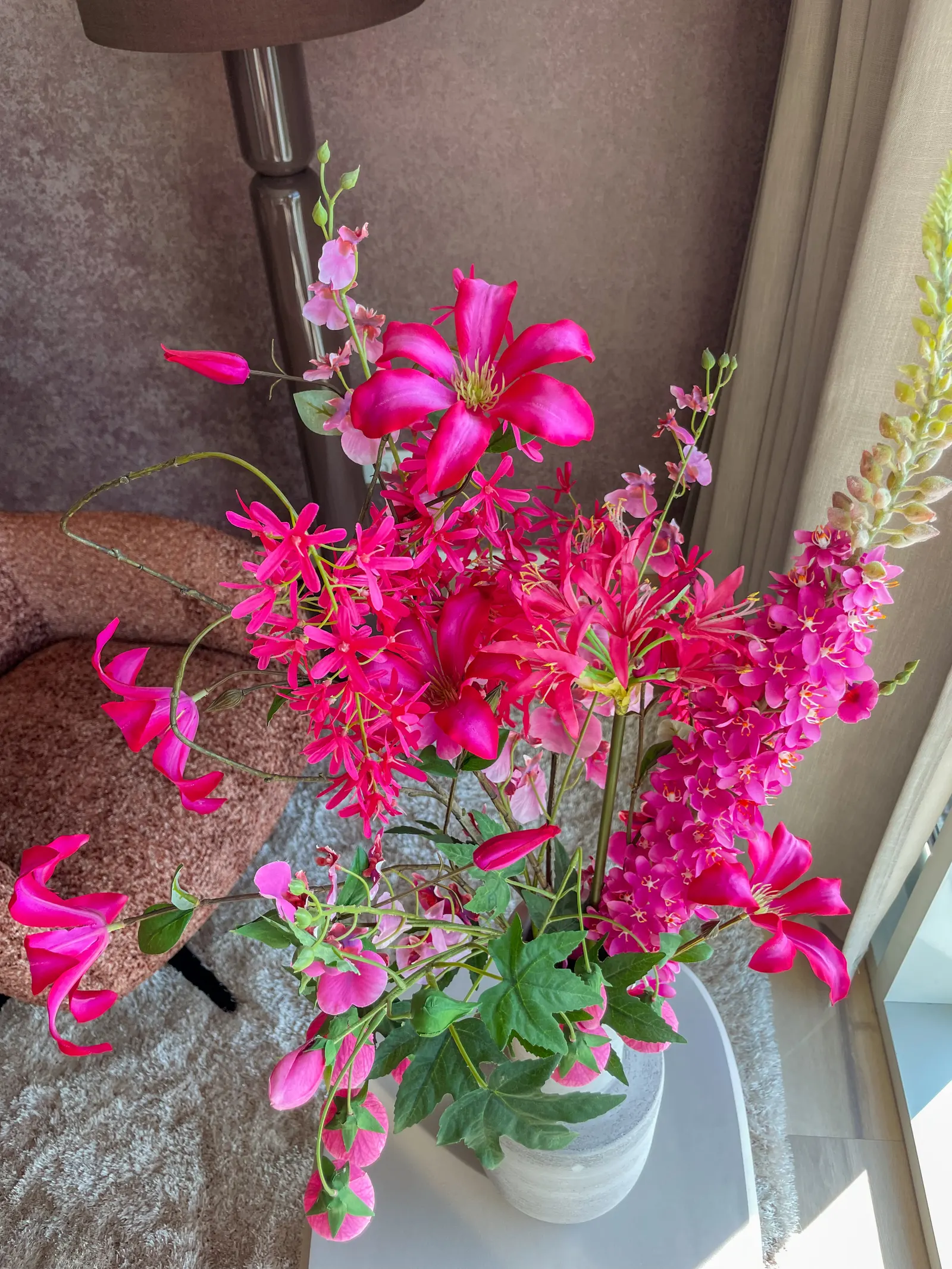Roze lelies in een vaas bij het raam