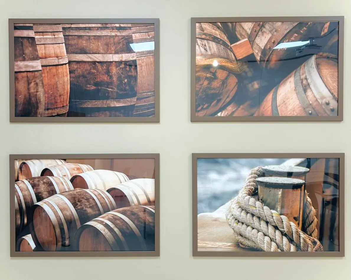 De vier ingelijste foto's van houten vaten aan de wand