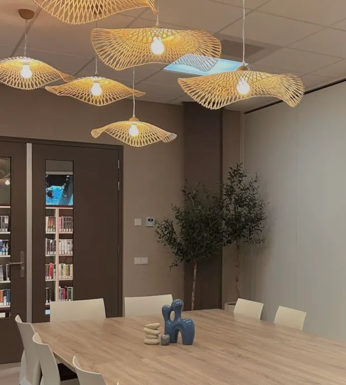 Rieten hanglampen met zicht op de boekenkasten van de bibliotheek