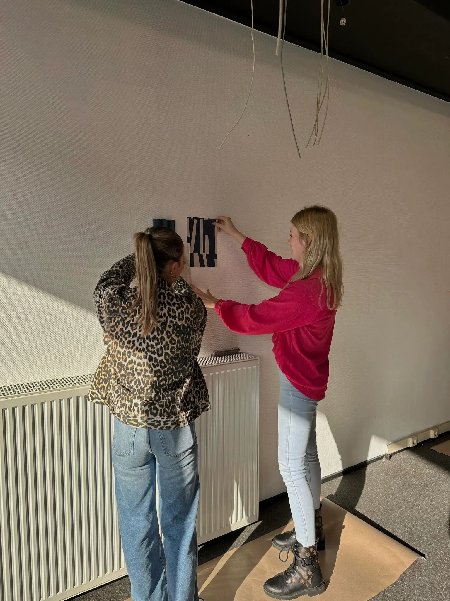 Materiaalstalen worden tegen de wand gepast bij BIZZ