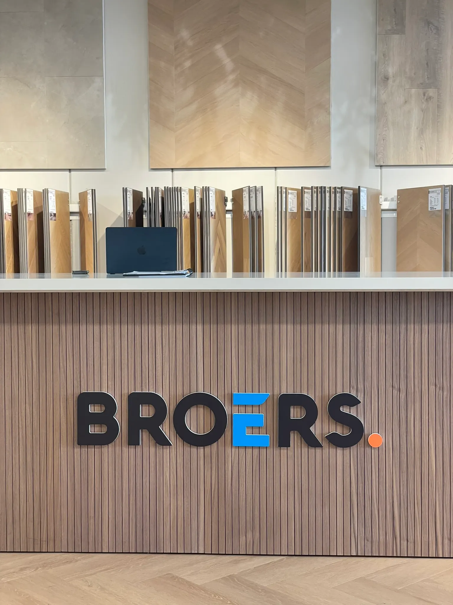 Het logo van Broers op de geribbelde houten balie