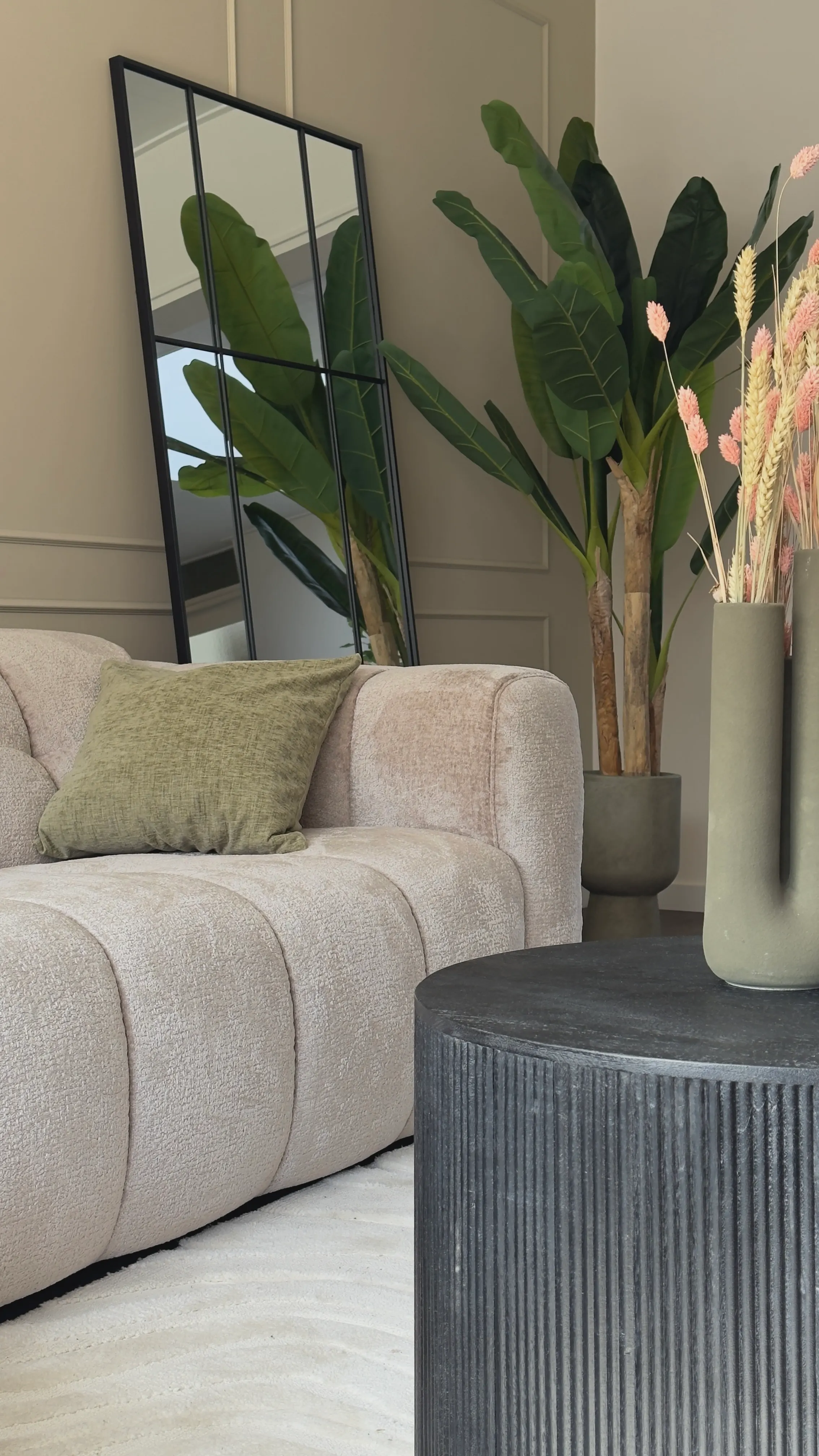 Bank met staande spiegel en bananenplant in de woning in Axel